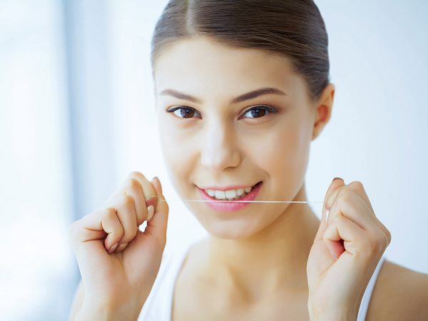 allaboutsmile-dental-holiday-care woman using dental floss