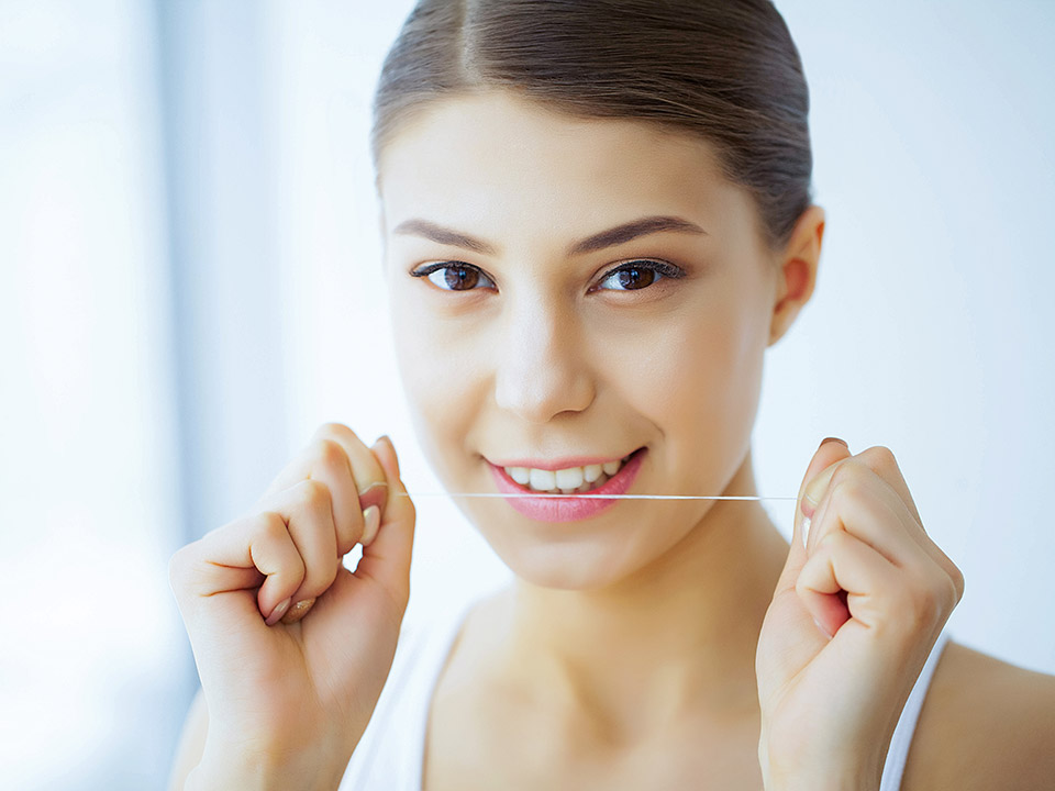 woman using dental floss