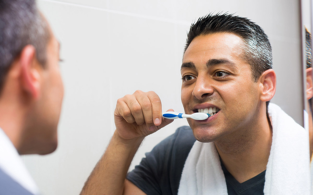 man brushing his teeth