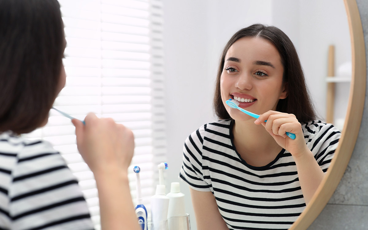 young woman brushing her teeth