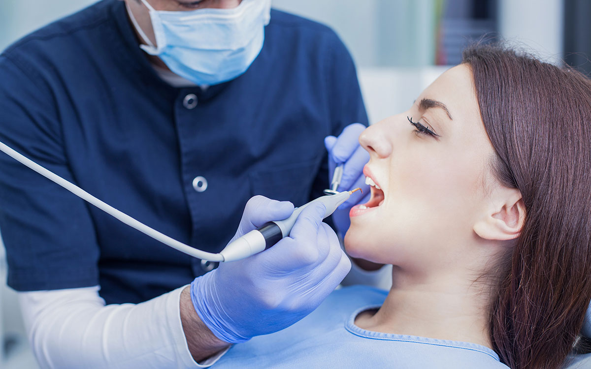 dentist cleaning patient teeth