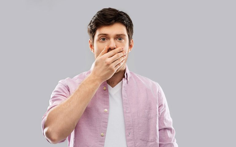man covering his mouth with his hand