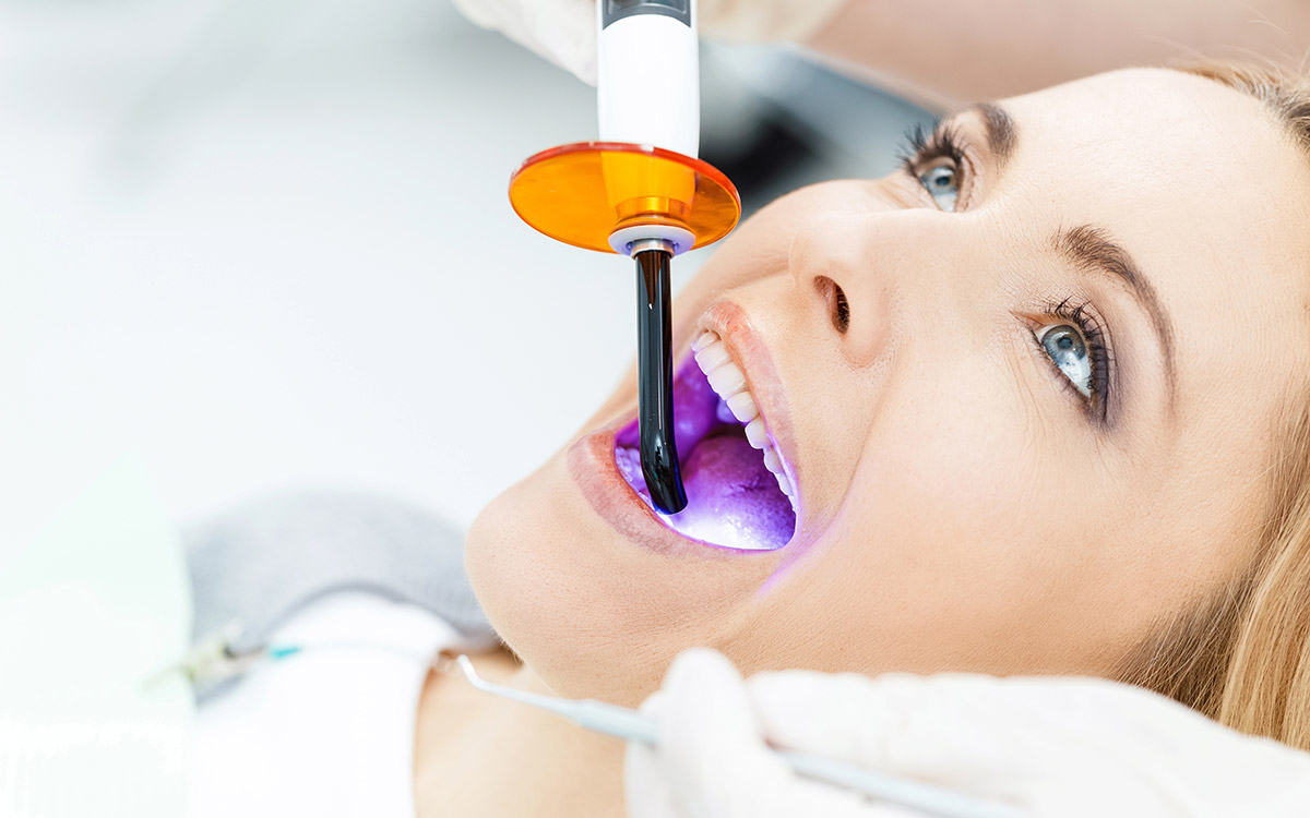 Patient whitening teeth at dentist