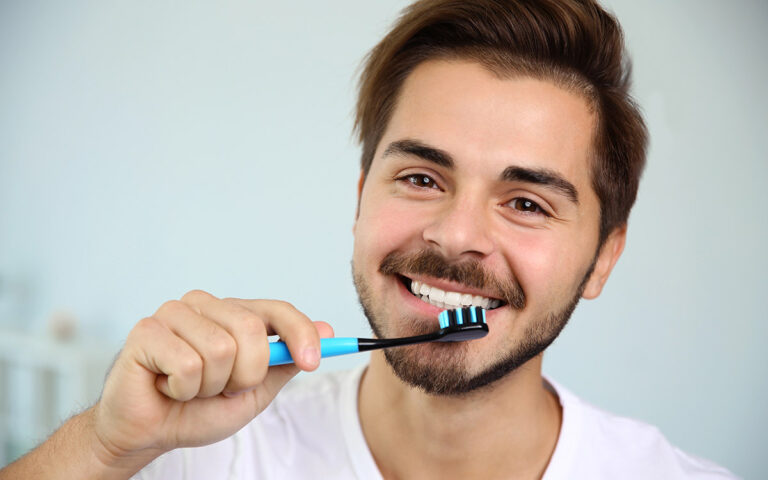 man smiling after brushing his teeth