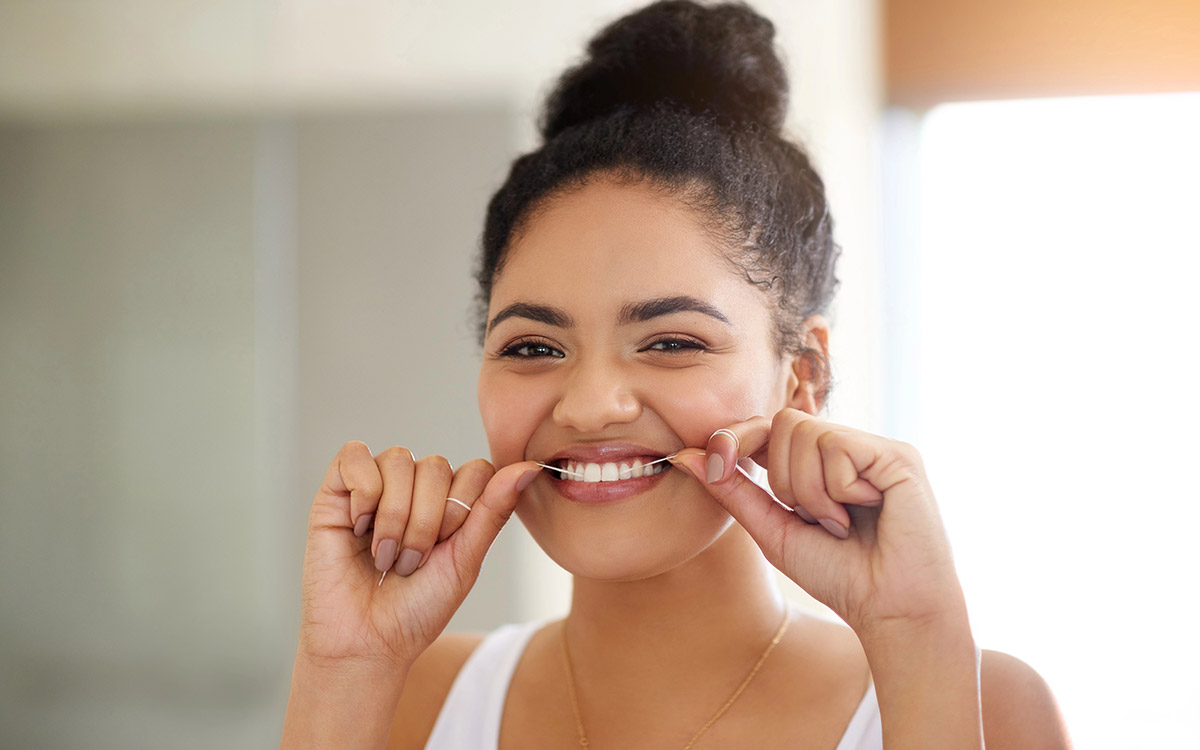 woman flossing her teeth