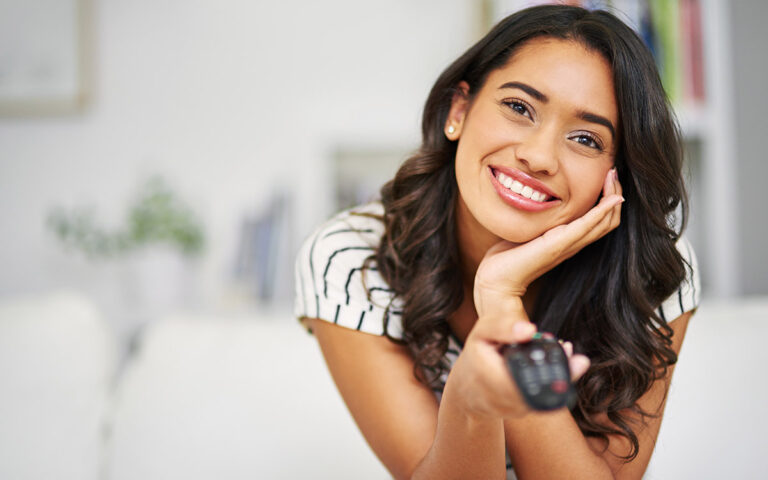 woman with confident smile watching tv