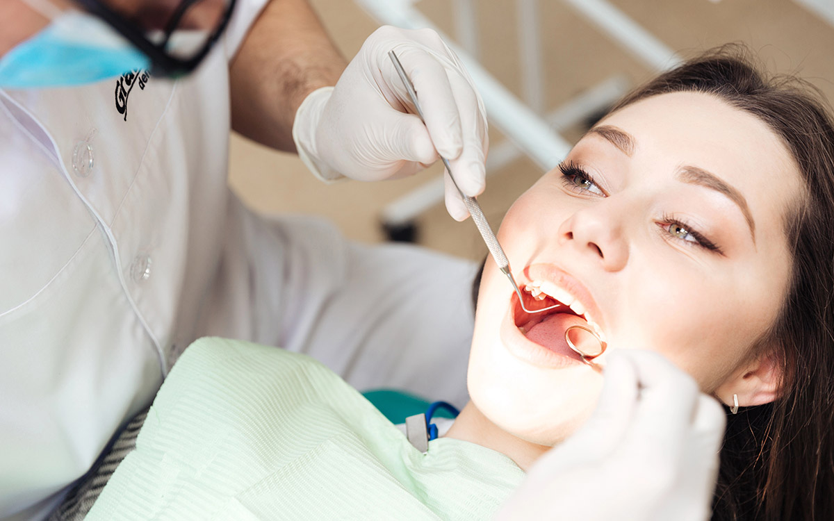 dentist checking patients teeth at the clinic