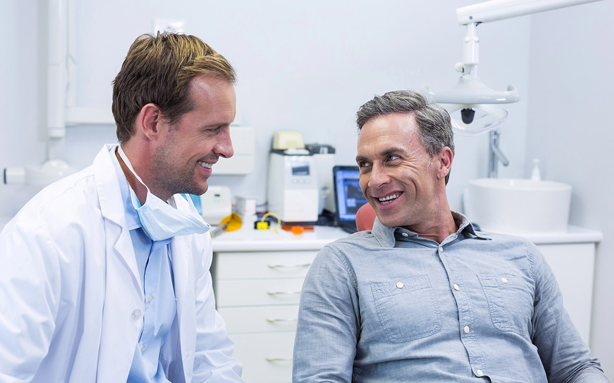 man smiling at her dental appointment