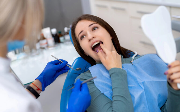 woman with her dentist pointing her gums